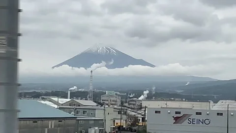 Scenic view of the iconic snow-capped Mount Fuji from a moving train Stock Footage 339652361