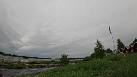 Scenic view of Kukkolankoski rapids with red wooden houses and Finnish flag Stock Footage 340651689