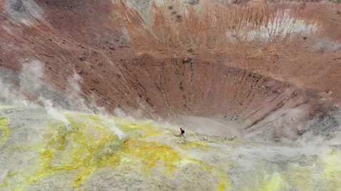 Scenic view of man walking trough smokes in volcano island Stock Footage 155200557
