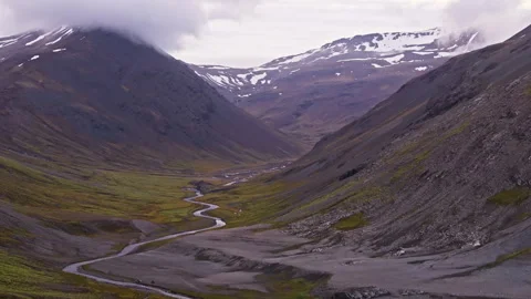Scenic View of a Meandering Stream and Snow-Patched Mountains in Iceland Stock Footage 337499990