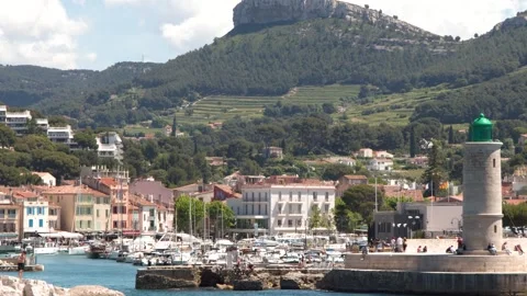 Scenic View of a Mediterranean Harbor with Lighthouse and Coastal Town Stockbeeldmateriaal 336935188