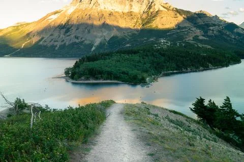 Scenic view with a mountain casting a shadow over a tranquil lake. Stock Photos