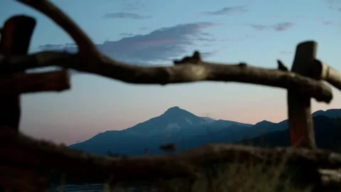 Scenic view of a mountain framed by a rustic wooden fence at dusk. The sky Stock Footage 318539938
