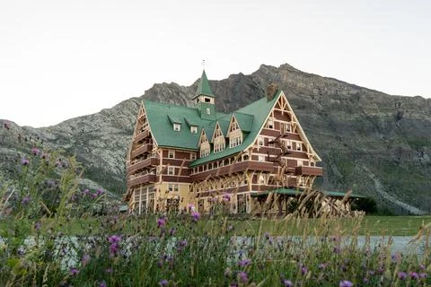 Scenic view of a mountain hotel with a backdrop of mountains and wildflowers Stock Photos