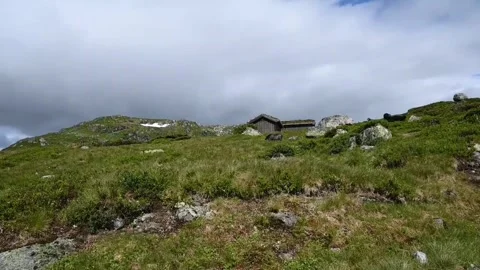 Scenic view of a mountain hut surrounded by grassy land and rocks in Norway.. Stock Footage 340201971