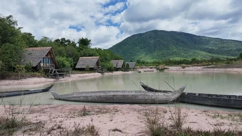 Scenic View of Mountain Lake with Rustic wooden rowboat and Bungalow in Cambodia 動画素材 336781243