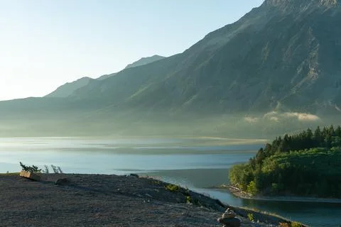 Scenic view of a mountain range and a lake in the background on a sunny day. Stock Photos