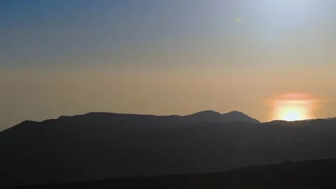 A scenic view of a mountain range silhouetted against a colorful sunset sky. Video stock 318648222