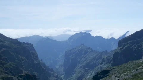 Scenic view of a mountain valley with clouds rolling over the peaks Stockbeeldmateriaal 333696056
