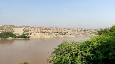 Scenic View Of The Muddy Indus River Flowing Through Hills Foto stock