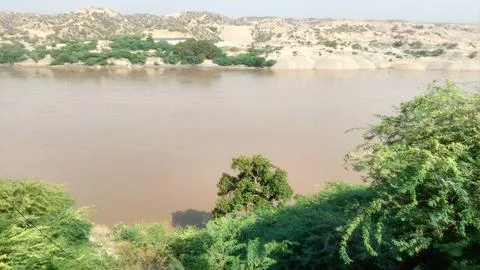 Scenic View Of The Muddy Indus River Flowing Through Hills Foto stock