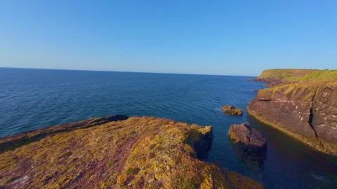 Scenic view of ocean cove surrounded by steep green cliffs in ireland Stock Footage 340433092
