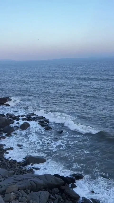 Scenic view of ocean waves crashing against rocky coastline during a peaceful Vídeos de archivo 334163401