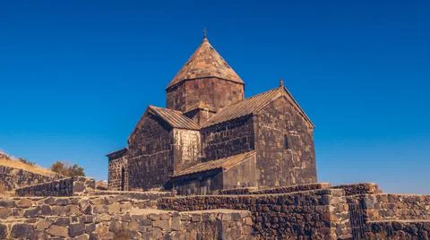 Scenic view of an old Sevanavank church in Sevan. Blue sky and bright autum c Stock Photos