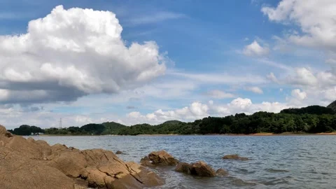 Scenic View of Red Maple Lake with Rocky Shoreline and Rolling Hills Video stock 347053360
