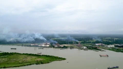 A scenic view of a river bordered by industrial facilities, with a small island  Stock Footage 287768978