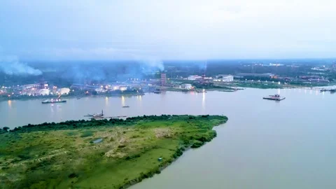A scenic view of a river bordered by industrial facilities, with a small island  Stock Footage 287769671