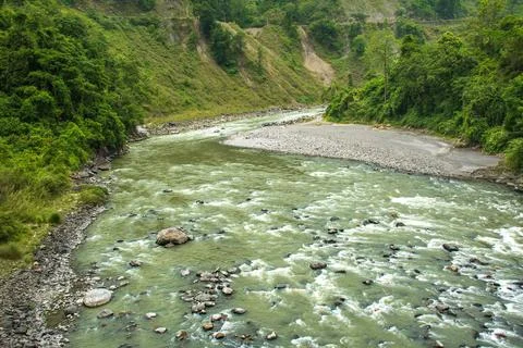 A scenic view of a river flowing through hilly landscape in Sikkim Foto stock