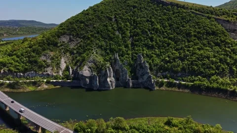 Scenic view of a river, mountains, and a highway during the day Stock Footage 338276274