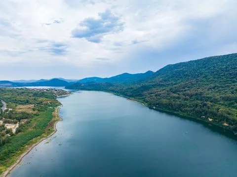 Scenic view of a river surrounded by green hills under a cloudy sky in the .. Stock-Fotos