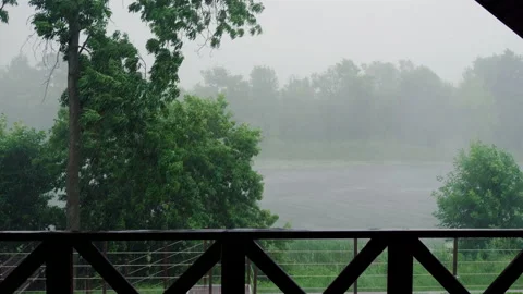 Scenic view of river from veranda of a dwelling house on a rainy summer day. 4K Stock Footage 130336632