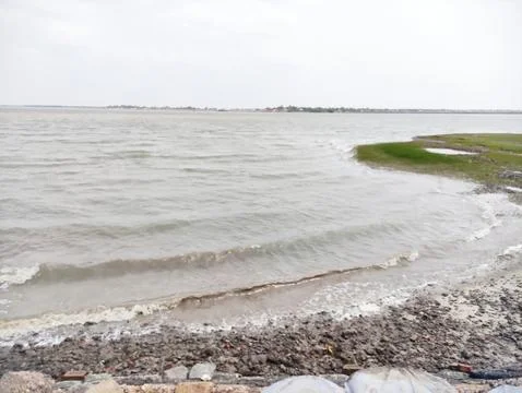 Scenic View of River Waves Hitting Shore with Green Bank Stock Photos