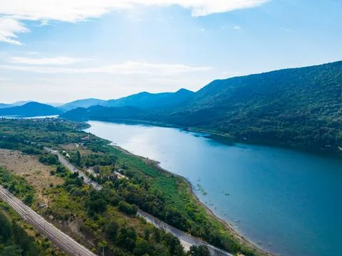 Scenic view of a river winding through mountains and lush fields in daylight Foto stock