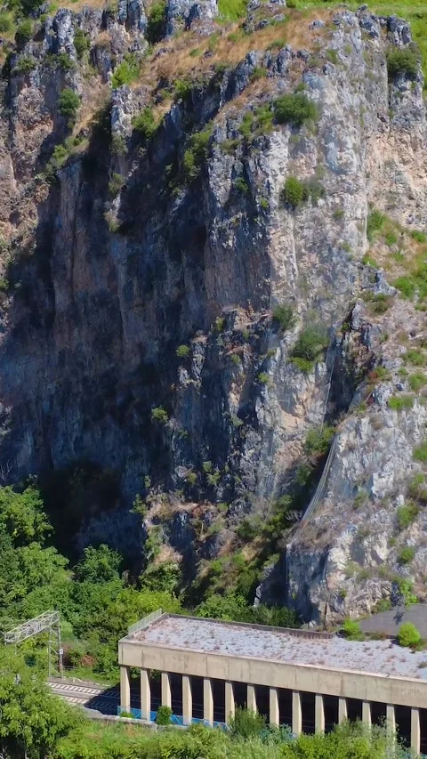 Scenic View of Rocky Cliffs and Lush Greenery Near an Old Structure in a Serene Stock Footage 317750265