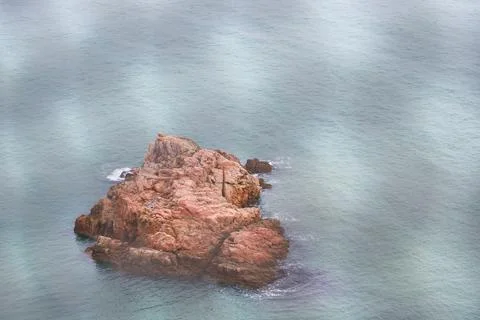 Scenic View of a Rocky Island Surrounded by Calm Waters Emphasizing Natures Foto stock