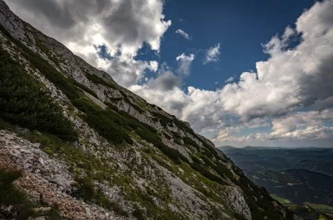 Scenic view on rocky route with dramatic cloudy sky and pine trees Stock Photos
