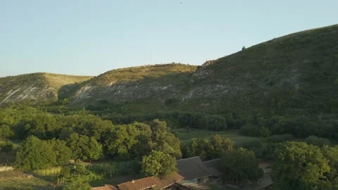 Scenic view of rolling hills and lush green trees transitioning to a rural Stock Footage 332725567