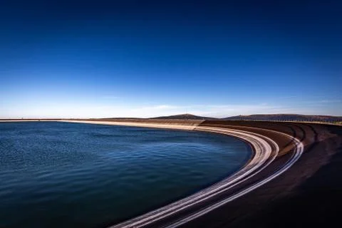 Scenic view on rounded edge of the upper water reservoire with dark blue sky Stock Photos