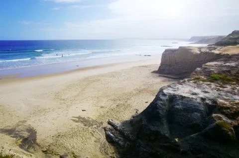 Scenic view of sandy beach, cliffs and blue sea. Stock Photos