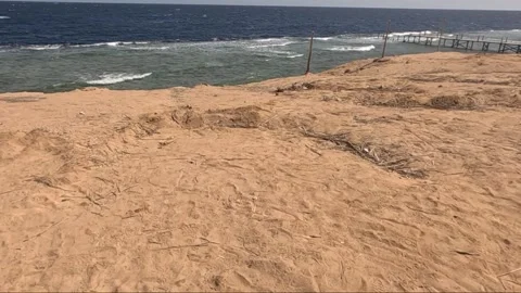 Scenic View of Sandy Shoreline Overlooking Vibrant Ocean Waves with Evidence of 库存影片 330100654