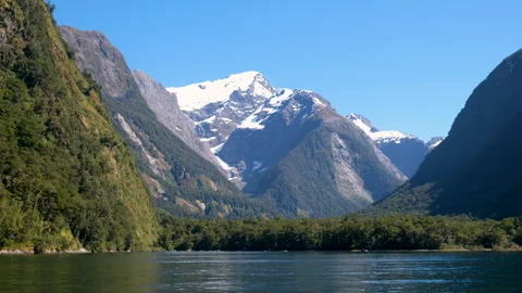 Scenic view of snow-capped mountains and forested cliffs from a boat 스톡 동영상 342000233