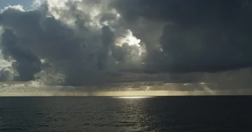 Scenic view of sun breaking through clouds at stormy sea Stock Footage 86111560