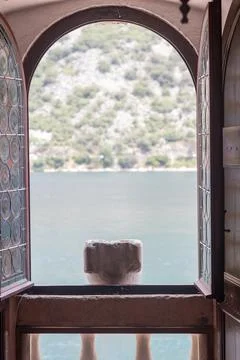 Scenic View Through an Arched Window to a Serene Lakeside Landscape, Perast.. Stock Photos