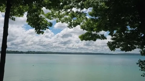 Scenic view through trees of a quiet lake Stock Footage 158999508