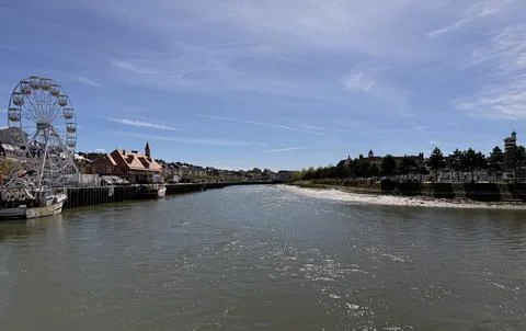 Scenic view of the Touques river with a small boat and Deauville coastline... Stock Photos