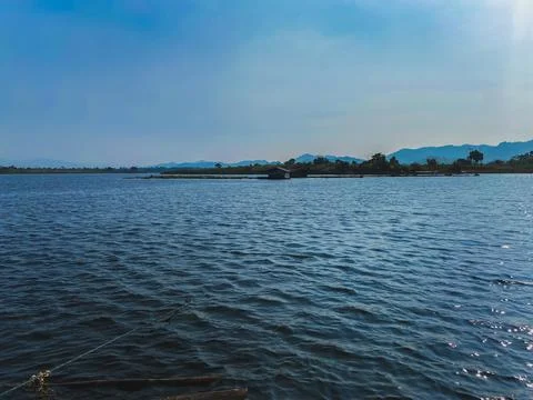 Scenic view of a tranquil lake with distant mountains and a small wooden st.. Foto stock