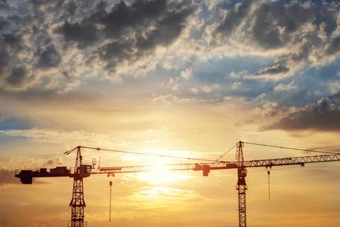 Scenic view of two high tower crane silhouette working at early sunrise time at 写真素材