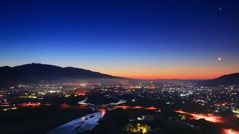 Scenic View of Ueda City, Mount Eboshi, and the Rising Sun and Moon from Chikuma Stock Footage 333209393