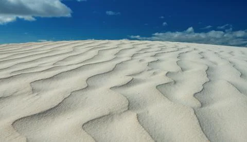 A scenic view of waves patterns on the sandy beach in Australia under a clear Foto stock