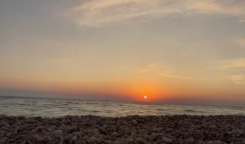 Scenic view of waves rushing at sandy beach against sky during sunset Stock Footage 273065697