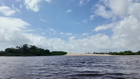 Scenic View of Wind Turbines Beyond Sand Dunes from Preguiça River in Maranhão Stock Footage 341408957