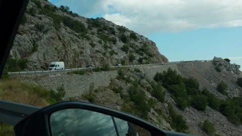 Scenic view of winding mountain road with vehicles driving Stock Footage 299896014