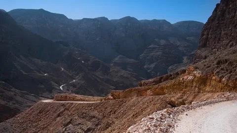 Scenic view of the winding road through the mountainous landscape of Wadi Shab, Stock Footage 318820438