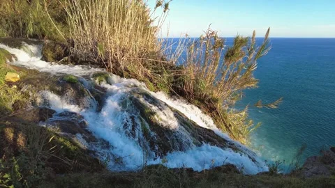 Scenic Water Flow Over Cliff Toward Mediterranean Sea in Antalya Stock Footage 333445711
