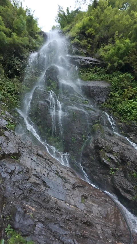 Scenic Waterfall Cascading Down Dark Rocky Cliffs on the Kedarnath Trekking Path Stock Footage 325015708