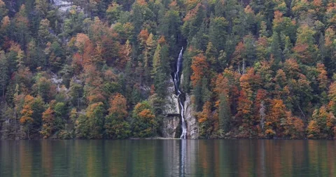 Scenic waterfall flowing into a lake during autumn at Konigssee and Alps mo.. Stock Footage 340486392